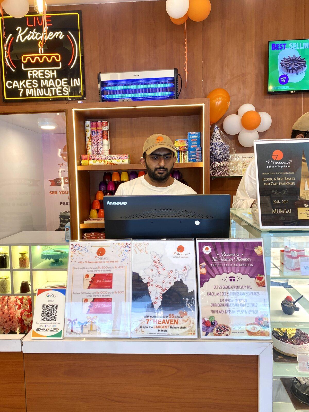 Nivesh working on a laptop behind a bakery counter